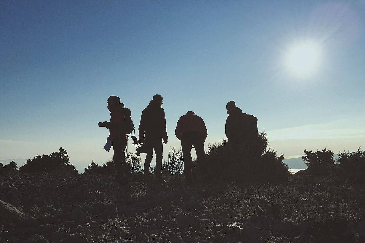 Silhuetas de um grupo de caminhantes ao sol